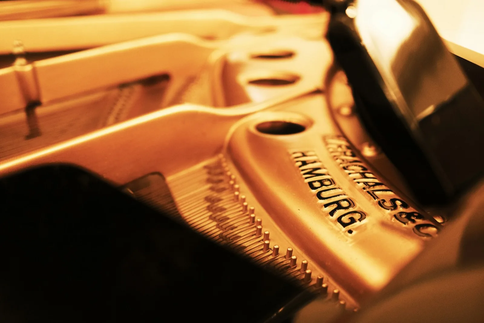 Piano strings and hammers in close-up, seen inside an open instrument