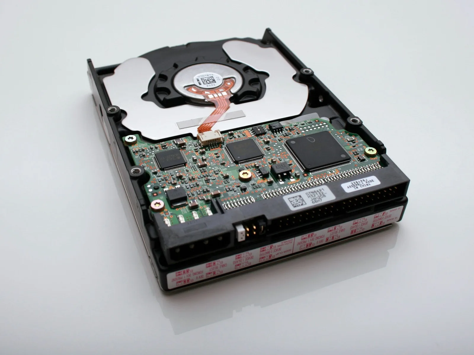 The exposed internals of a hard drive, platter and arm in close-up