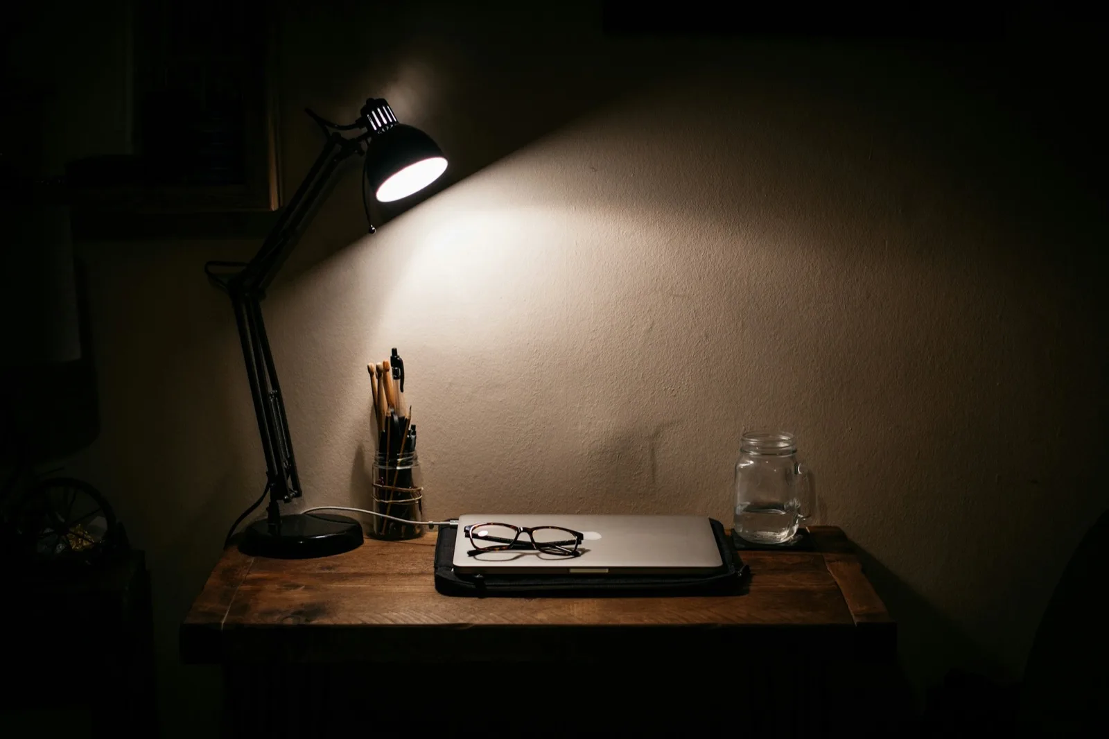 A black desk lamp on a wooden table